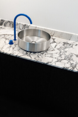 Bold blue faucet in modern Gutleutstraße kitchen adding a pop of color to the sleek design before matter, architecture & interior design studio Frankfurt am Main