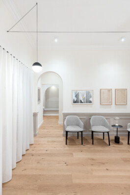 Neutral tones and light wood flooring create a calming waiting area at Guiollettstraße before matter, architecture & interior design studio Frankfurt am Main