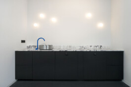 Seamless stainless steel sink in minimalist kitchen at Gutleutstraße, Modern kitchen layout at Gutleutstraße with matte black cabinetry and soft lighting before matter, architecture & interior design studio Frankfurt am Main